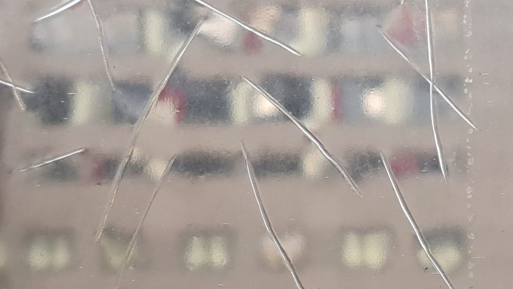 Verschwommene Aussicht durch zerkratztes Fenster