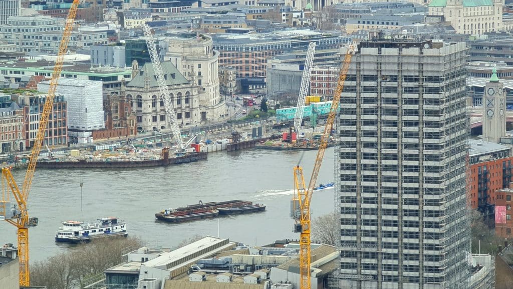 Flusslandschaft mit Baukränen und Gebäuden