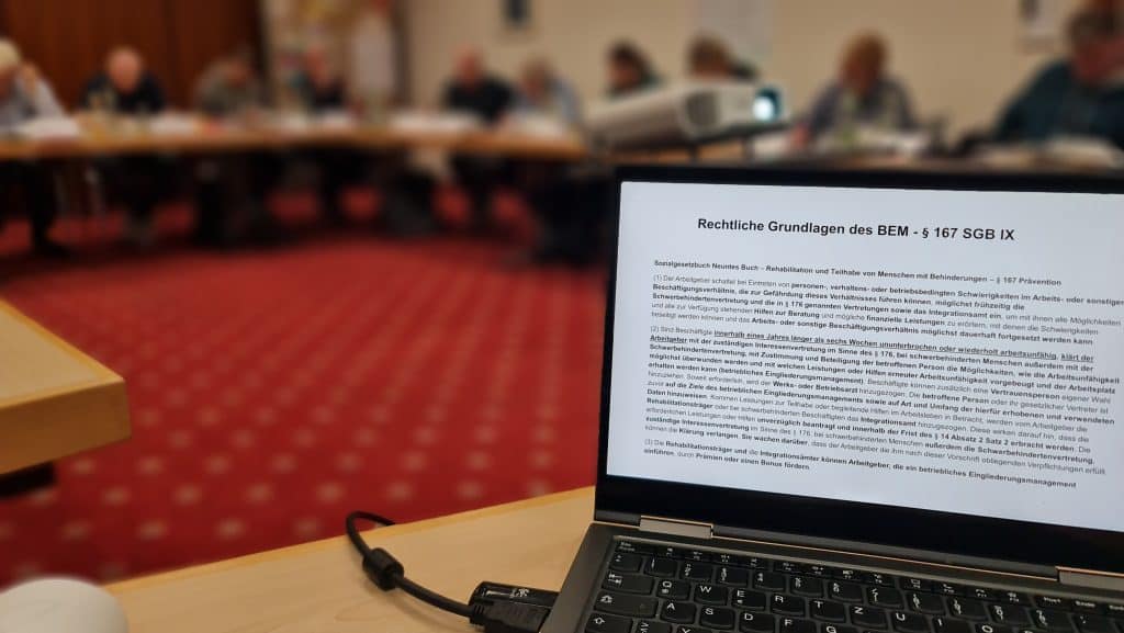 Laptop mit rechtlichem Dokument und verschwommenem Hintergrund.