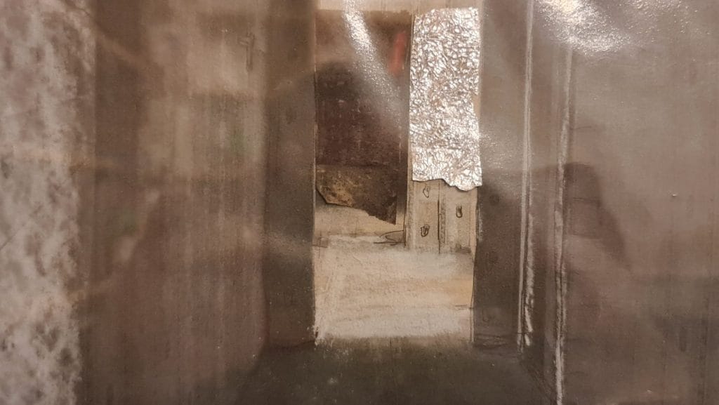 Schmaler Flur mit offener Tür und Metallfolie.