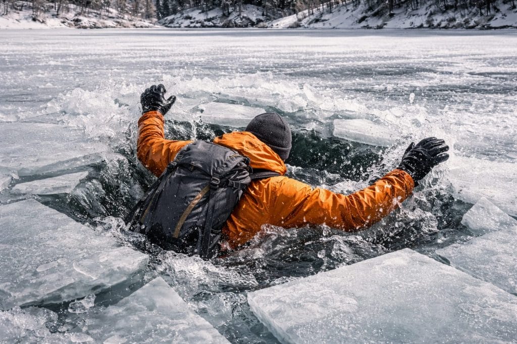 Person im Eis eingebrochen auf gefrorenem See.